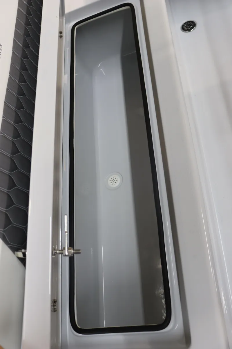 Slide: The Image of 2025 Hewes 16 Redfisher boat storage compartment with sleek design and drain. - 18