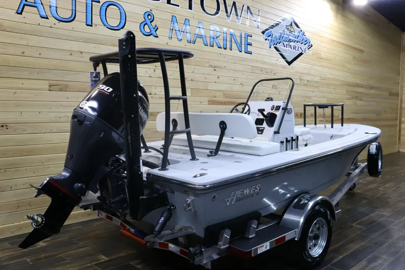 Slide: The Image of 2025 Hewes 16 Redfisher boat displayed indoors with Yamaha outboard motor. - 2