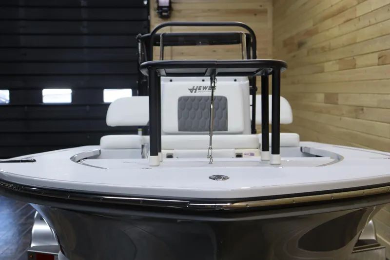 Slide: The Image of 2025 Hewes 16 Redfisher boat in showroom, front view, wooden wall background. - 8