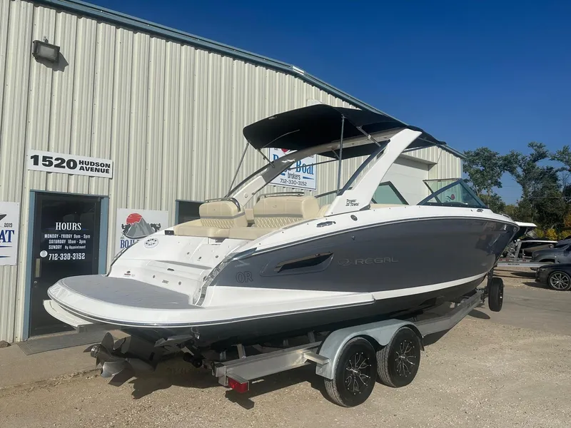 Slide: The Image of 2023 Regal 2800 boat on trailer outside dealership, sunny day. - 1