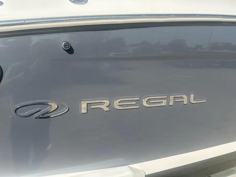 Slide: The Image of 2023 Regal 2800 boat logo on sleek gray hull. - 2