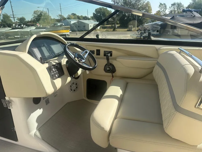 Slide: The Image of 2023 Regal 2800 boat interior with steering wheel and beige seating. - 28