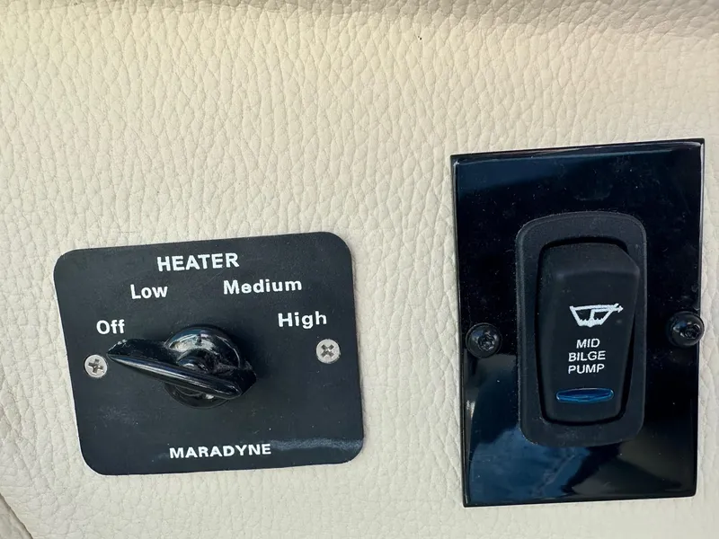 Slide: The Image of 2023 Regal 2800 boat heater and bilge pump controls on leather panel. - 40