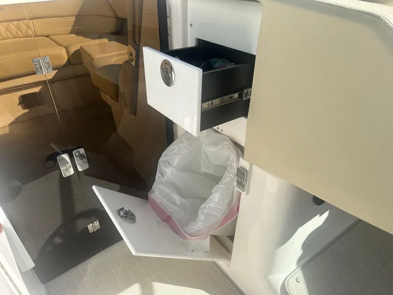 Slide: The Image of 2023 Regal 2800 boat interior with open drawer and trash compartment. - 42