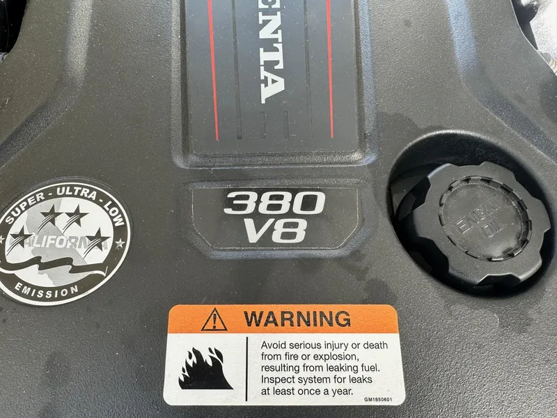 Slide: The Image of Close-up of 2023 Regal 2800 engine cover, featuring 380 V8 and warning label. - 43