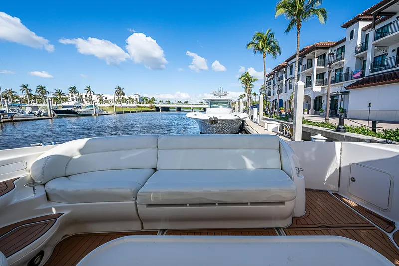 Slide: The Image of Luxurious 2002 Sea Ray 510 Sundancer yacht with white seating, docked by waterfront homes. - 17