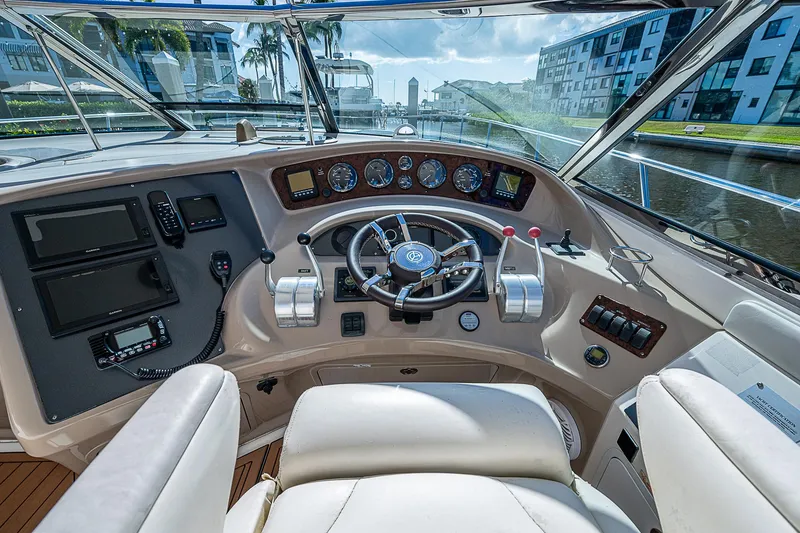 Slide: The Image of 2002 Sea Ray 510 Sundancer helm with modern controls and waterfront view. - 24