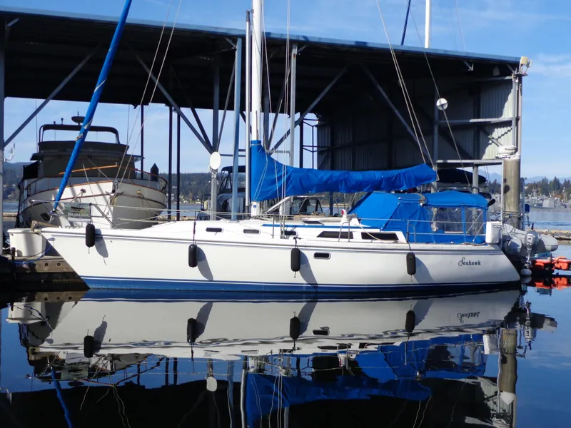 The Image of 1991 Catalina MK-l Double Cabin sailboat docked in marina, reflecting on calm water. - 0