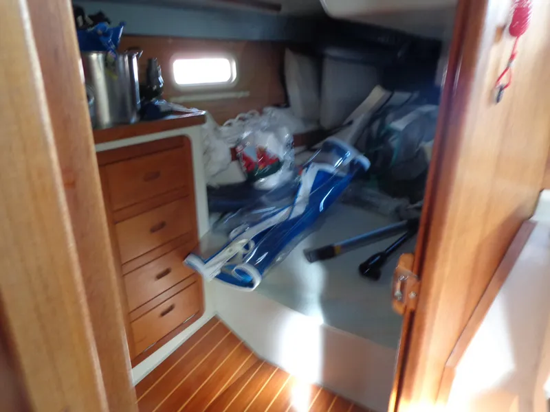 Slide: The Image of 1991 Catalina MK-l Double Cabin interior with wooden drawers and cluttered bed. - 16