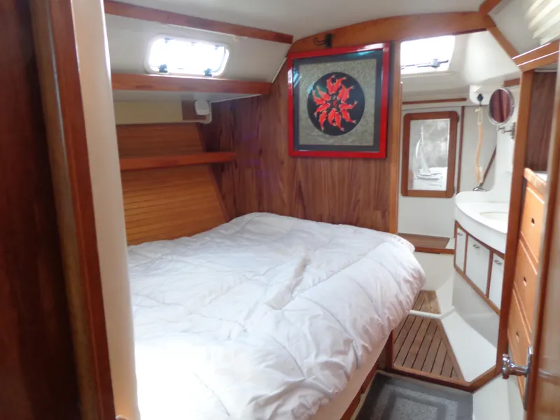 Slide: The Image of Cozy cabin interior of 1991 Catalina MK-l Double, featuring a comfortable bed and wooden accents. - 22