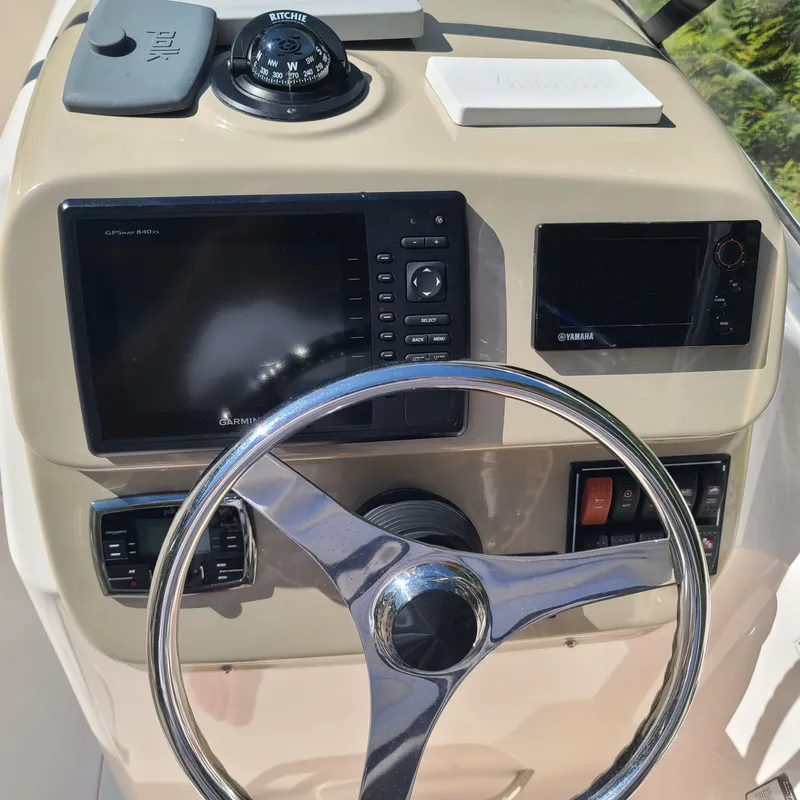 Slide: The Image of 2015 Pursuit DC 235 Dual Console dashboard with steering wheel and navigation instruments. - 11