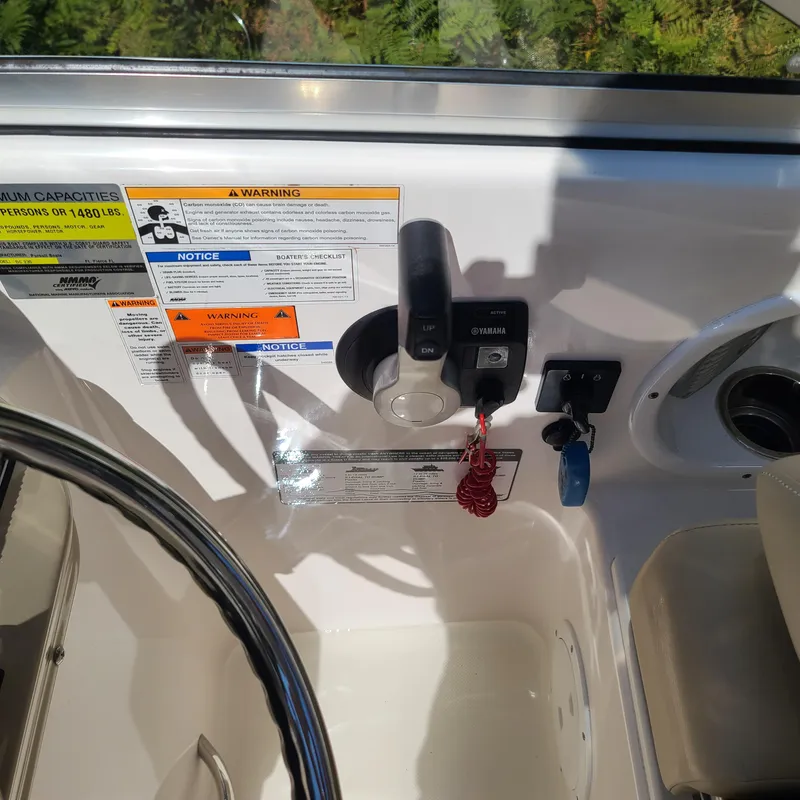 Slide: The Image of 2015 Pursuit DC 235 Dual Console boat controls and warning labels. - 12