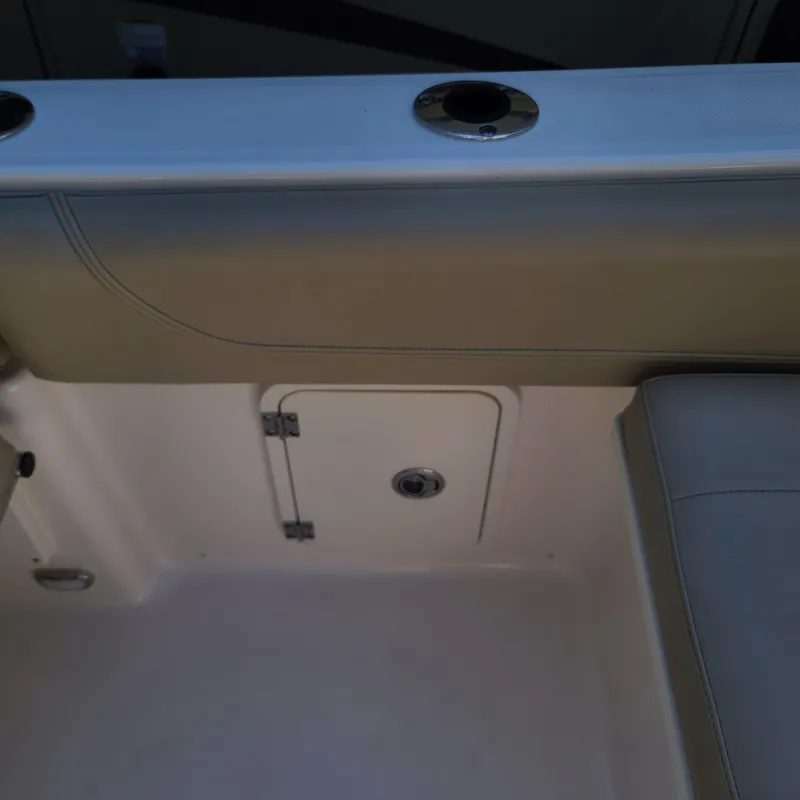 Slide: The Image of Interior view of 2015 Pursuit DC 235 Dual Console boat, featuring seating and storage compartment. - 13