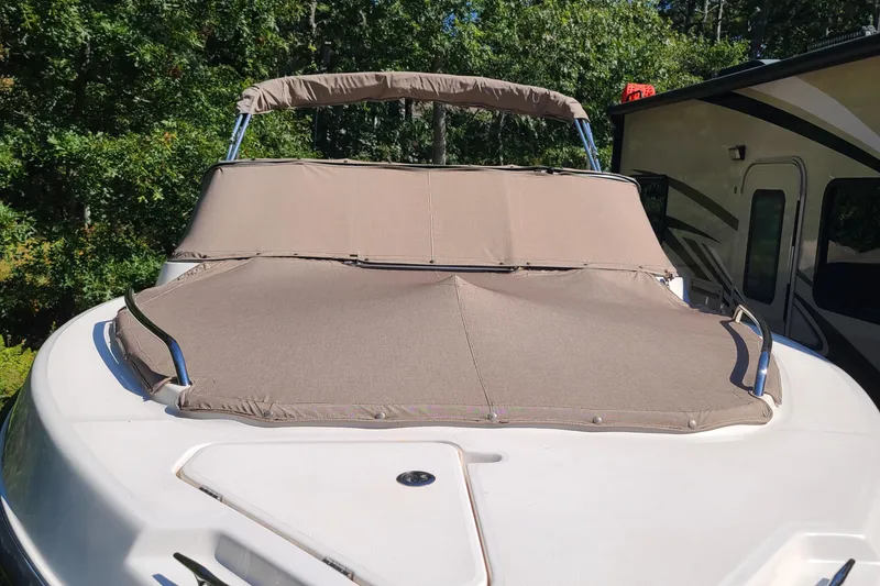 Slide: The Image of 2015 Pursuit DC 235 Dual Console boat with protective cover, parked outdoors. - 23