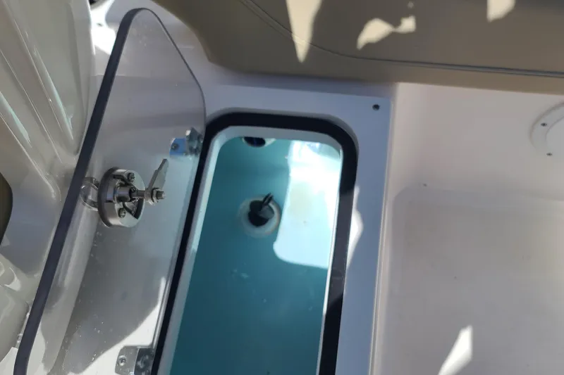 Slide: The Image of Open storage compartment on 2015 Pursuit DC 235 Dual Console boat. - 28