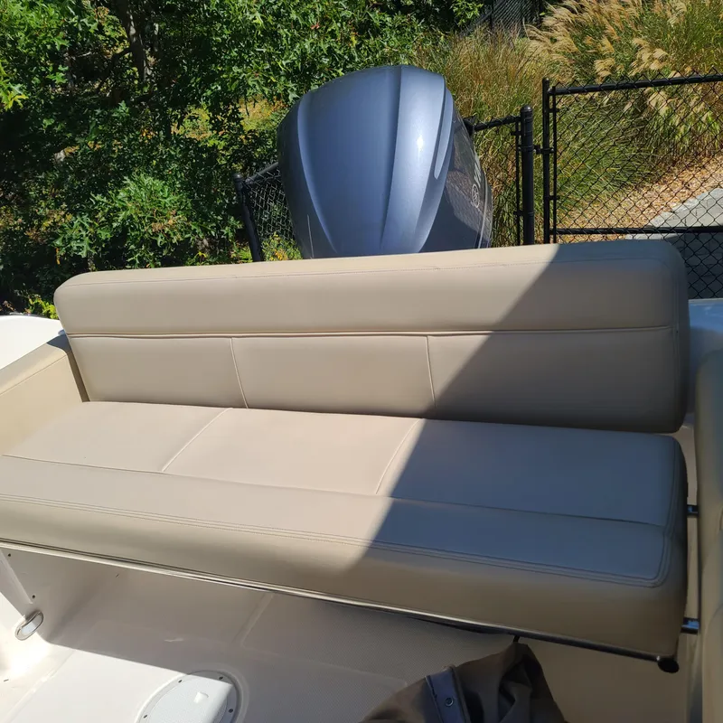 Slide: The Image of 2015 Pursuit DC 235 Dual Console boat with beige seating and outboard motor. - 8