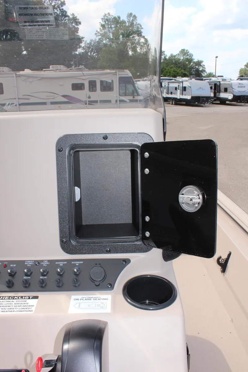 Slide: The Image of 2025 Avid 18 Rogue CC boat dashboard with open storage compartment. - 18