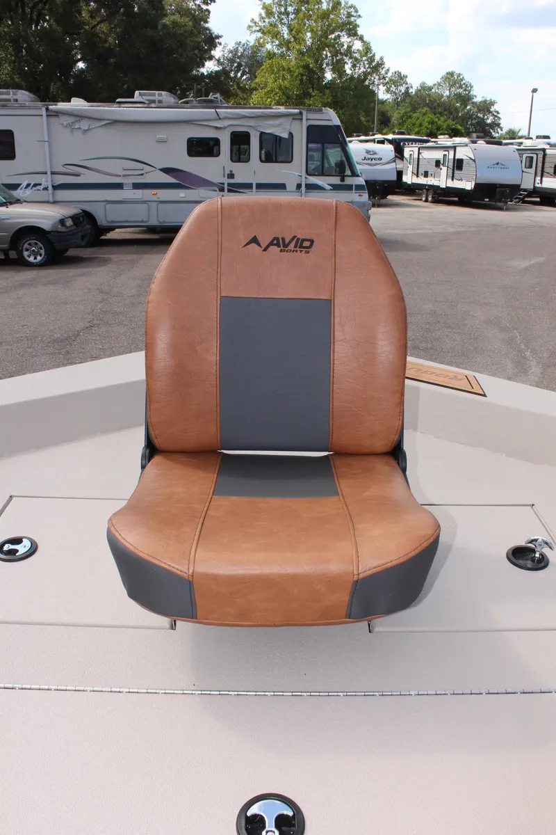 Slide: The Image of Avid 18 Rogue CC 2025 boat seat, brown and gray leather, in outdoor setting. - 20