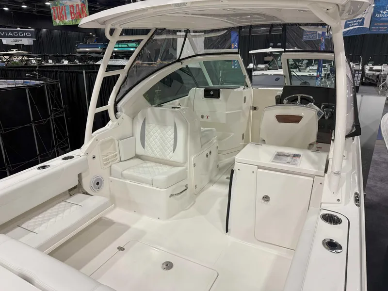 Slide: The Image of 2025 Pursuit DC 266 Dual Console boat interior with white seating and modern dashboard. - 6