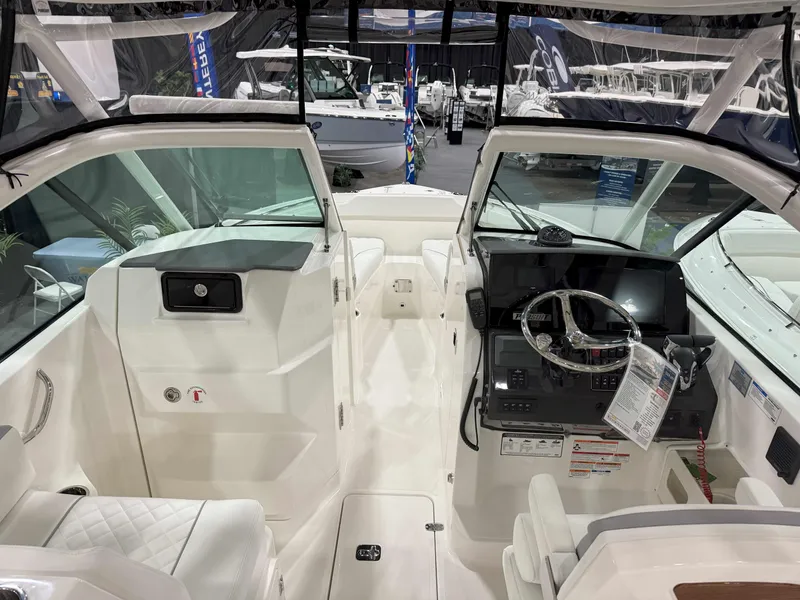 Slide: The Image of 2025 Pursuit DC 266 Dual Console boat interior with steering wheel and seating. - 7