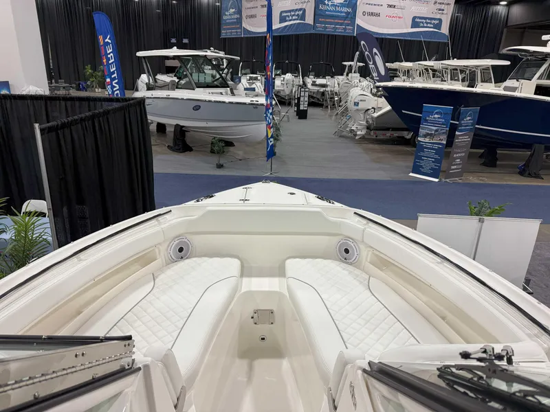 Slide: The Image of 2025 Pursuit DC 266 Dual Console boat displayed at an indoor boat show. - 8