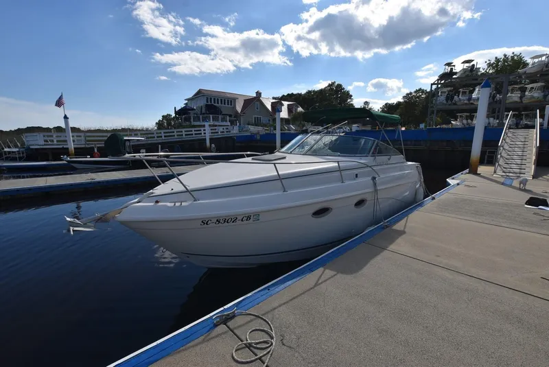 Slide: The Image of 1999 Rinker 270 Fiesta Vee boat docked at marina under blue sky. - 3