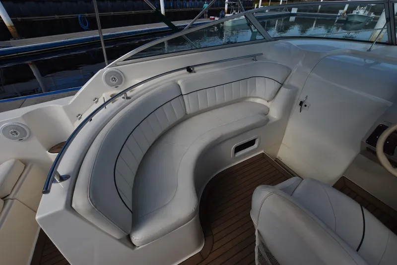 Slide: The Image of 1999 Rinker 270 Fiesta Vee boat interior with curved seating and wood flooring. - 7