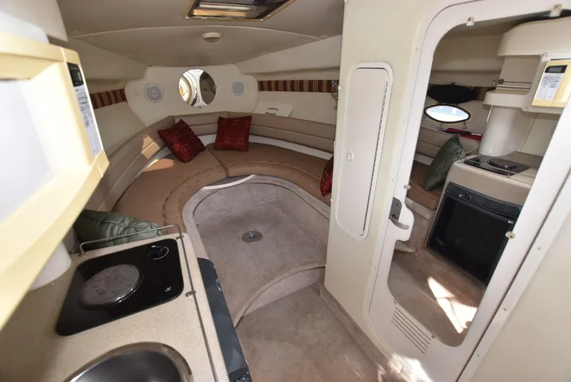 Slide: The Image of Interior of 1999 Rinker 270 Fiesta Vee boat with kitchenette and seating area. - 9