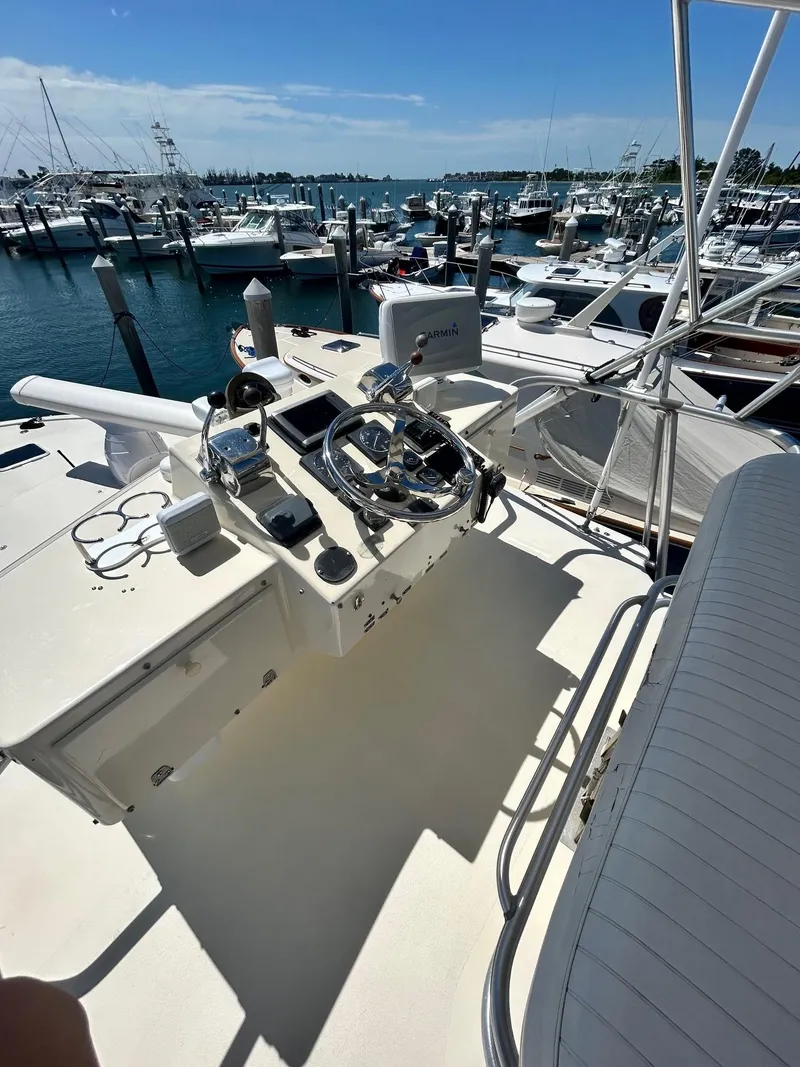 Slide: The Image of 1985 Viking Express boat helm with marina view, featuring steering wheel and controls. - 12