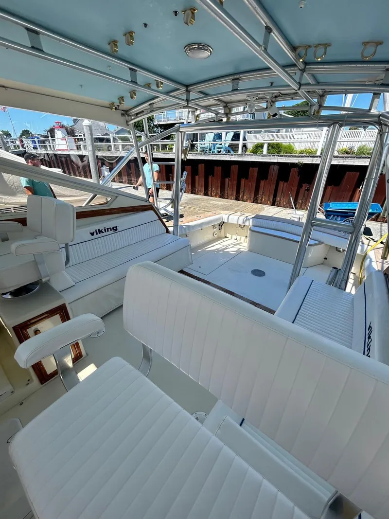Slide: The Image of 1985 Viking Express boat interior with white seating and metal framework at a dock. - 16