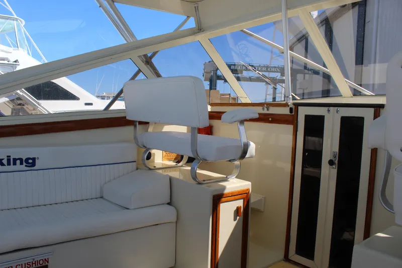 Slide: The Image of Interior of a 1985 Viking Express boat with white seating and wooden accents. - 17