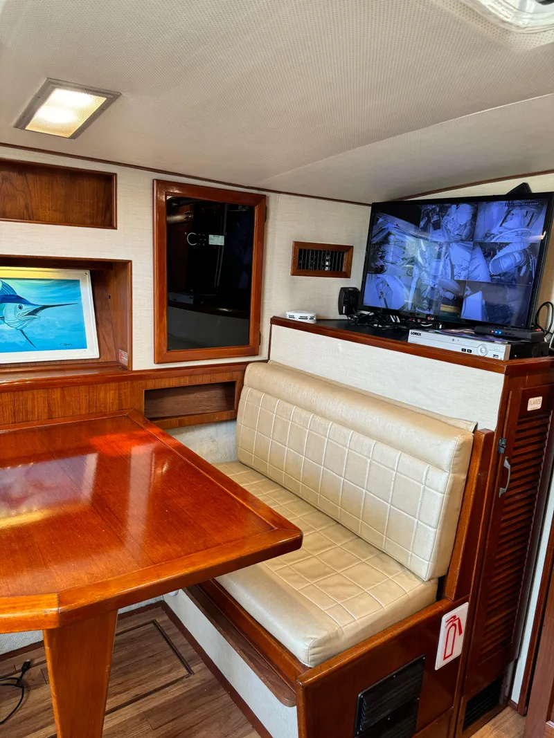 Slide: The Image of 1985 Viking Express boat interior with dining area, TV, and wooden accents. - 26