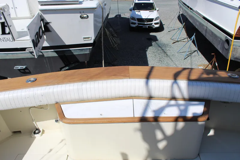 Slide: The Image of 1985 Viking Express boat interior with wood trim, docked near other boats and a car. - 8