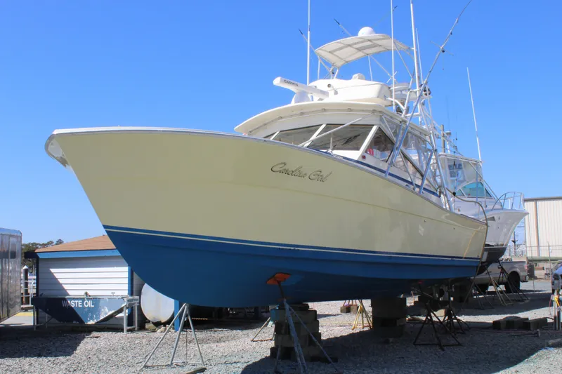 Slide: The Image of 1985 Viking Express boat on dry dock, blue and white hull, clear sky background. - 30