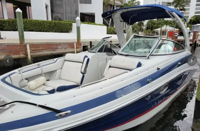 Slide: The Image of 2020 Crownline Eclipse E255 XS boat docked, featuring blue and white design with spacious seating. - 1