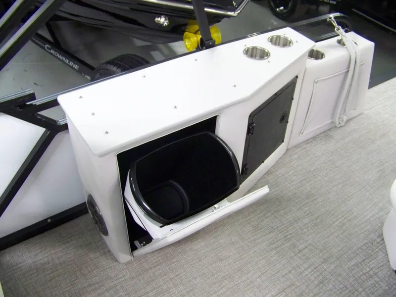 Slide: The Image of 2025 Avalon LSZ23CRB boat interior with storage compartment and cup holders. - 6