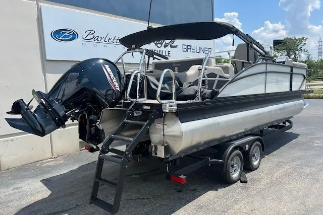 Slide: The Image of 2025 Barletta C22UC pontoon boat on trailer, featuring Mercury outboard motor. - 2