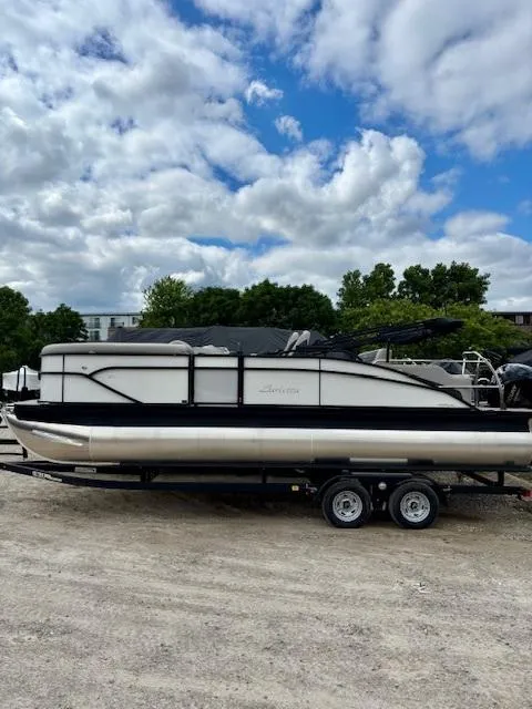 Slide: The Image of 2025 Barletta C22UC pontoon boat on trailer under cloudy sky. - 3