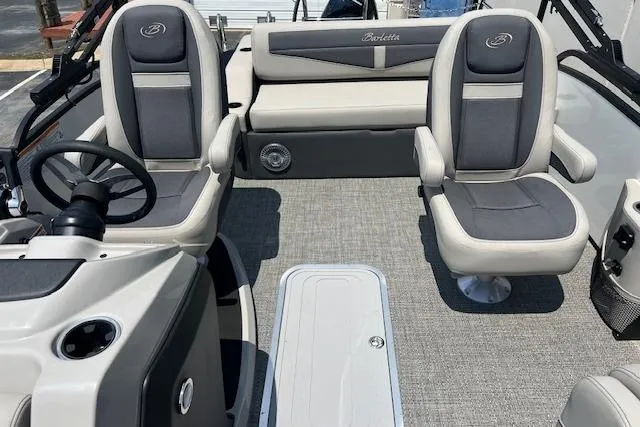 Slide: The Image of 2025 Barletta C22UC boat interior with gray seating and steering wheel. - 6