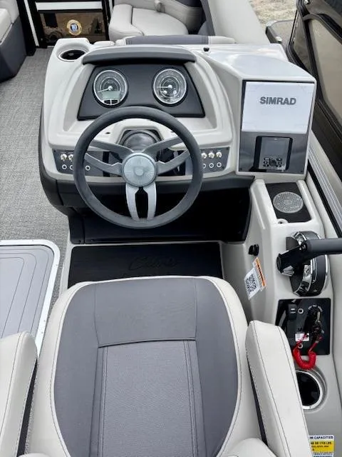 Slide: The Image of 2025 Barletta C22UC boat dashboard with steering wheel and Simrad display. - 7