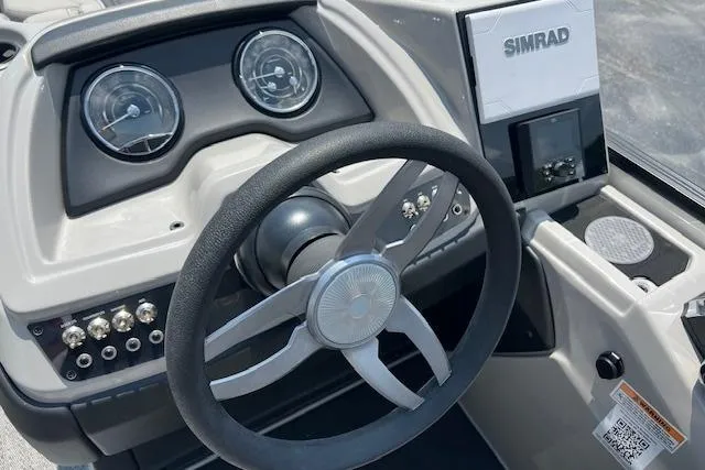 Slide: The Image of 2025 Barletta C22UC boat dashboard with steering wheel and Simrad display. - 9