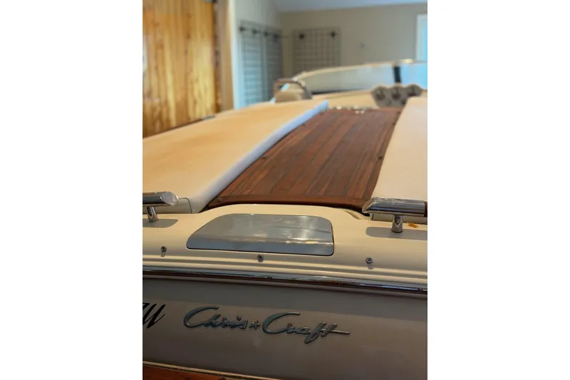 Slide: The Image of 2014 Chris-Craft Capri 21 boat in indoor storage, showcasing elegant design and craftsmanship. - 1