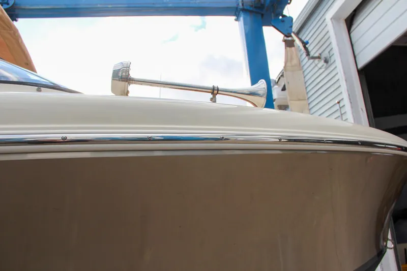 Slide: The Image of 2014 Chris-Craft Capri 21 boat with tan canopy and luxurious interior in a marina setting. - 11