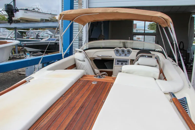 Slide: The Image of 2014 Chris-Craft Capri 21 boat detail with chrome accents and horn, docked near a building. - 15