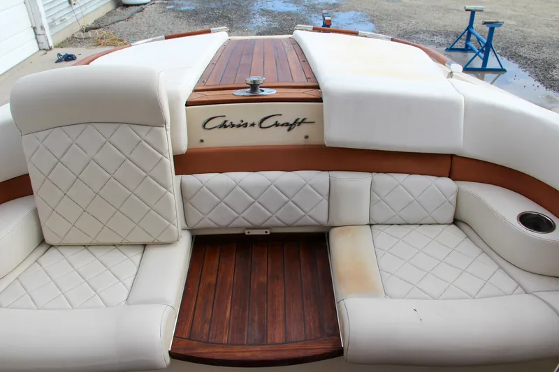 Slide: The Image of 2014 Chris-Craft Capri 21 boat underside on blue stands, showcasing propeller and rudder. - 17