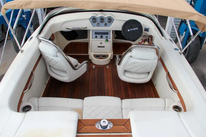 Slide: The Image of 2014 Chris-Craft Capri 21 boat with polished wooden deck in a workshop setting. - 34