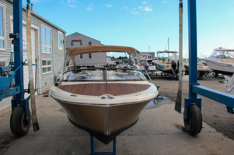 Slide: The Image of 2014 Chris-Craft Capri 21 boat interior with white leather seats and wooden flooring. - 35