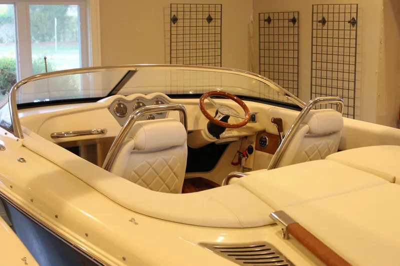 Slide: The Image of 2014 Chris-Craft Capri 21 interior with elegant white seating and wooden steering wheel. - 42