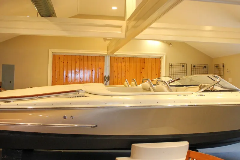 Slide: The Image of 2014 Chris-Craft Capri 21 boat in indoor storage, showcasing sleek design and luxury features. - 44