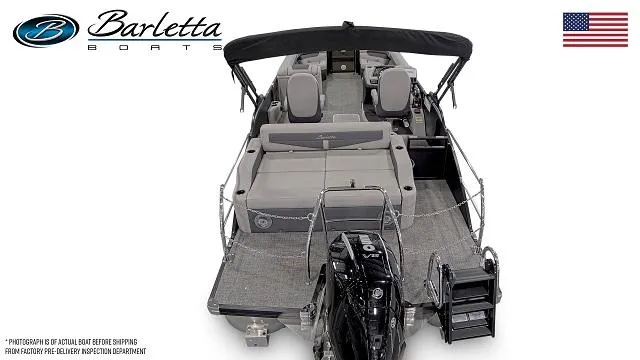 Slide: The Image of 2025 Barletta C24UC pontoon boat with seating, motor, and canopy, displayed with American flag. - 12